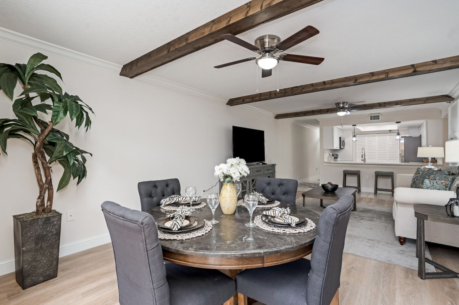 A dining room with a table and chairs and a ceiling fan.