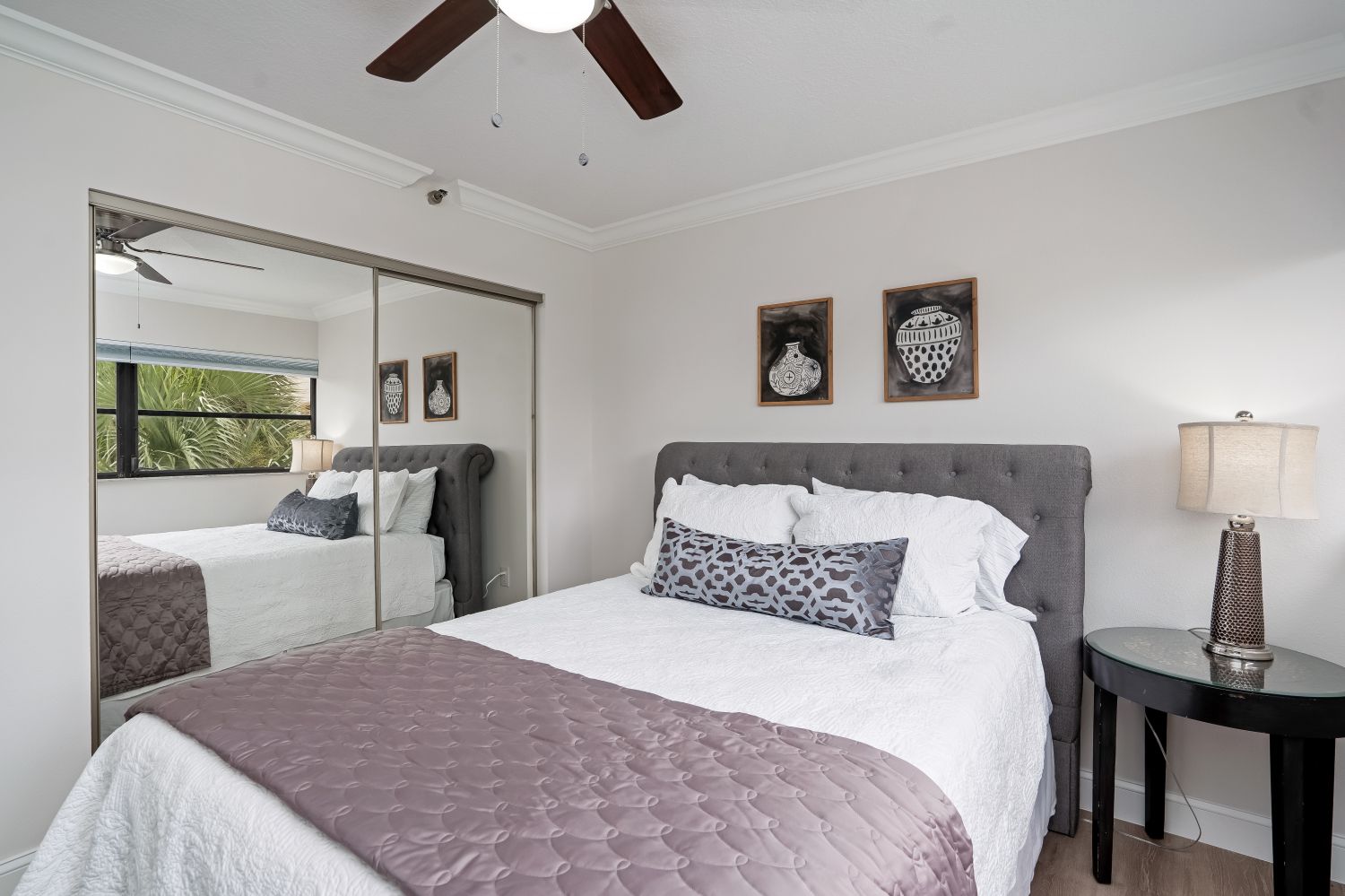 A bedroom with a bed and a ceiling fan.