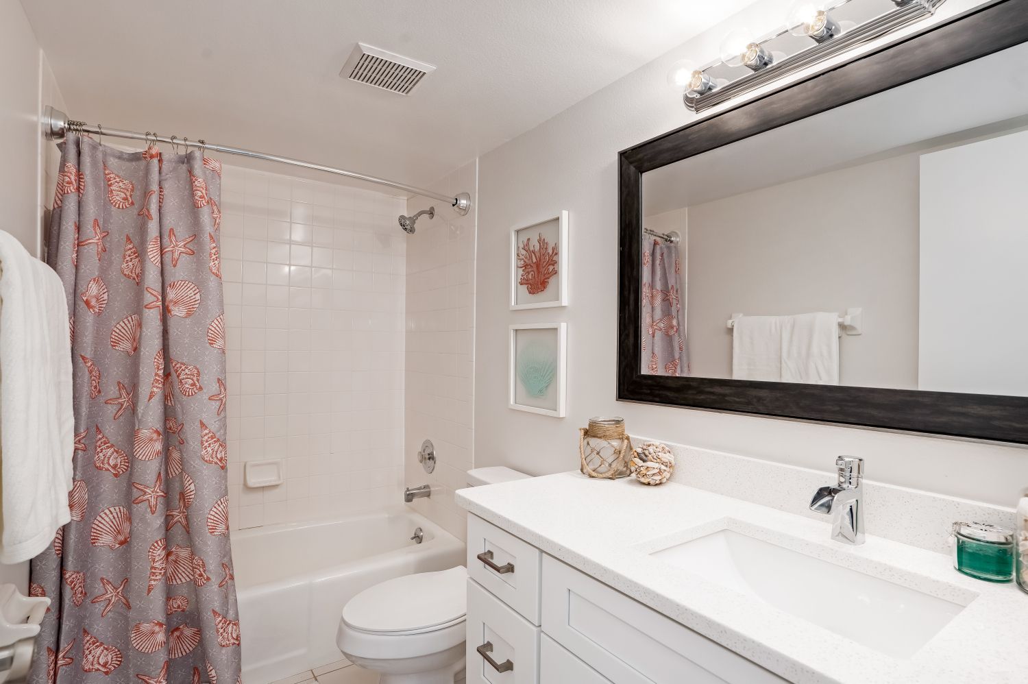 A bathroom with a toilet , sink , shower and mirror.