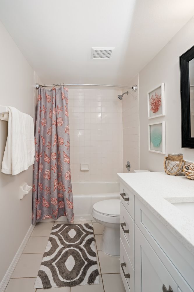 A bathroom with a toilet , sink , bathtub and shower curtain.