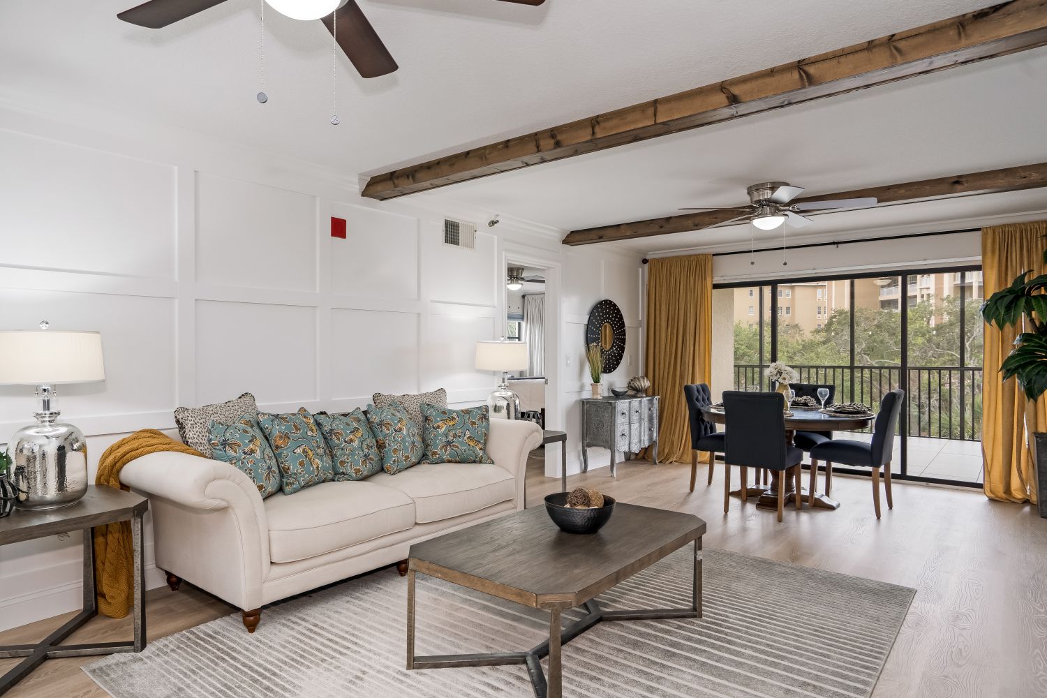 A living room with a couch , coffee table , and ceiling fan.