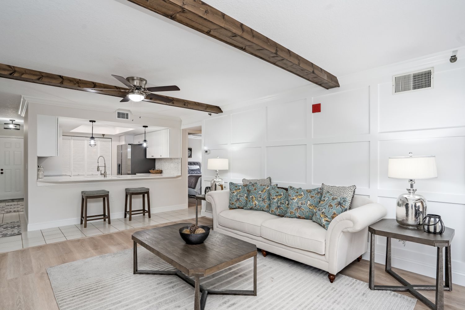 A living room with a couch , coffee table , and ceiling fan.