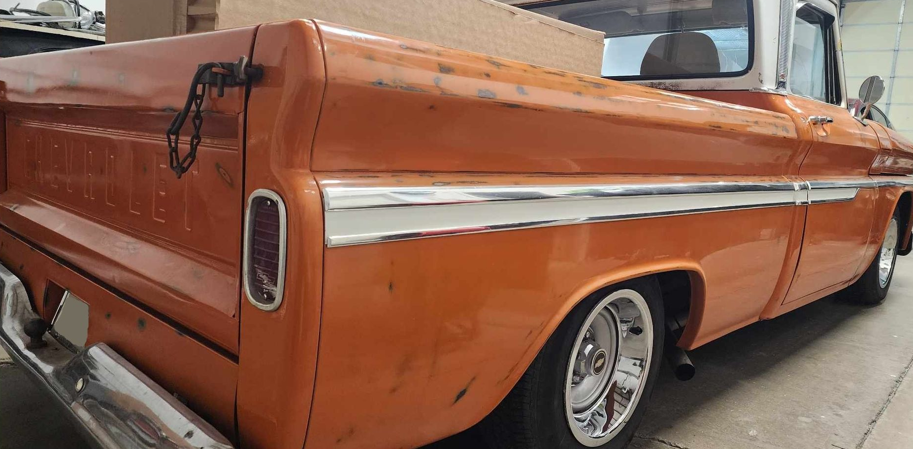 Orange vintage pickup truck with chrome accents and white top.