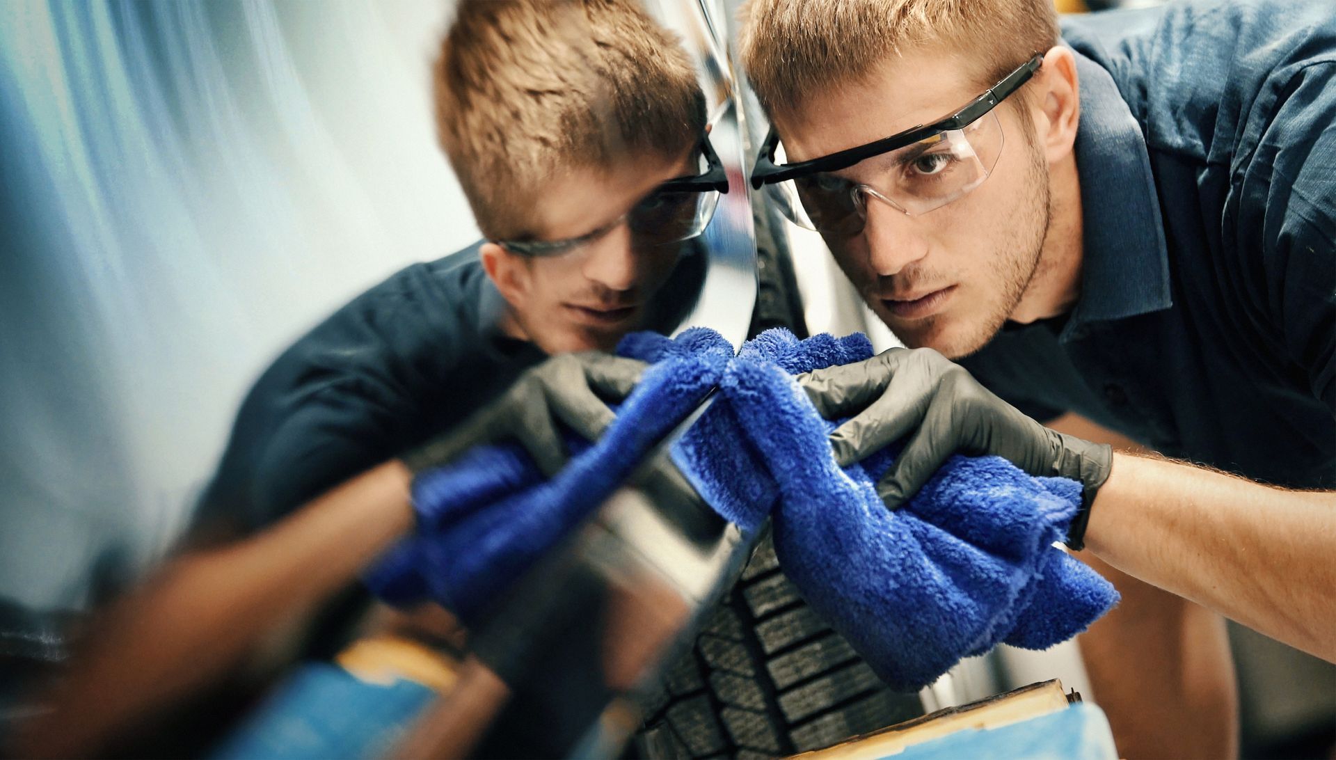 A car is being washed with a high pressure washer.