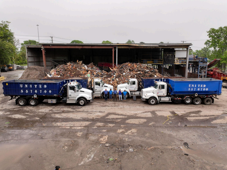 A group of dump trucks are parked in front of a building.