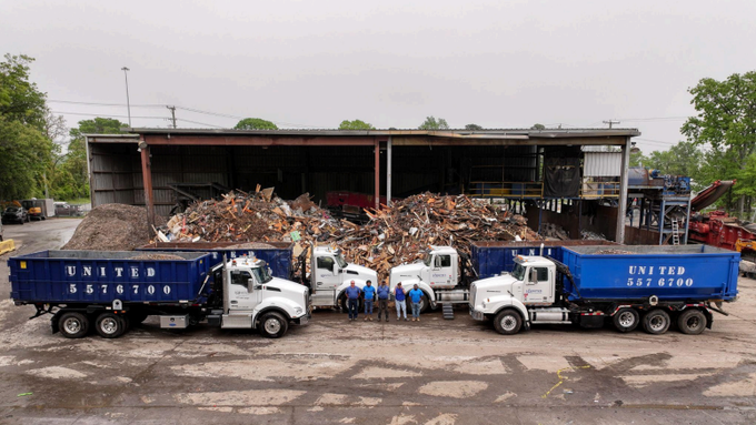 A group of dump trucks are parked in front of a building.
