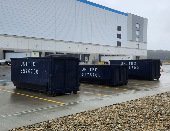 A blue dumpster from united is parked in a parking lot A blue dumpster from united is parked in a parking lot