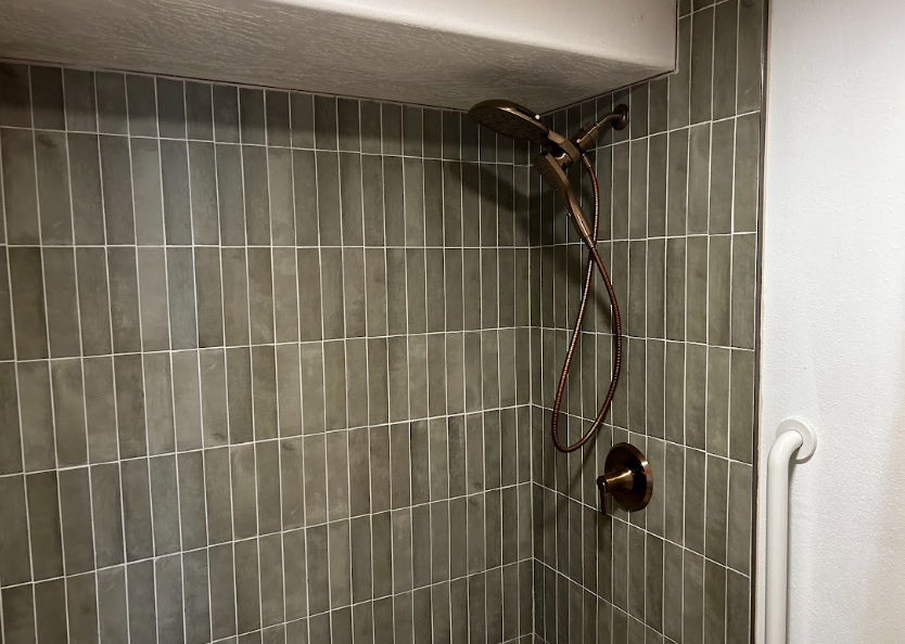 A bathroom under construction with buckets of paint and a ladder.