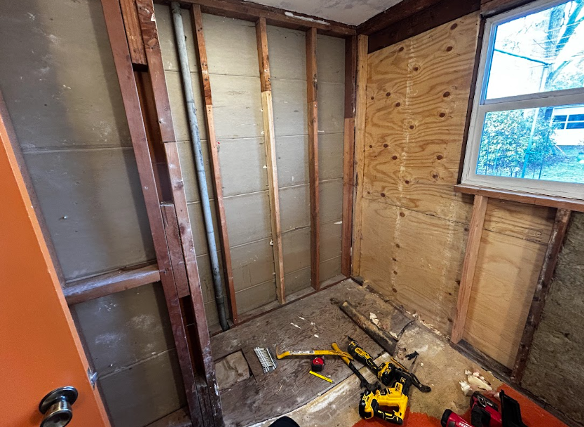 A kitchen is being remodeled with two men working on it