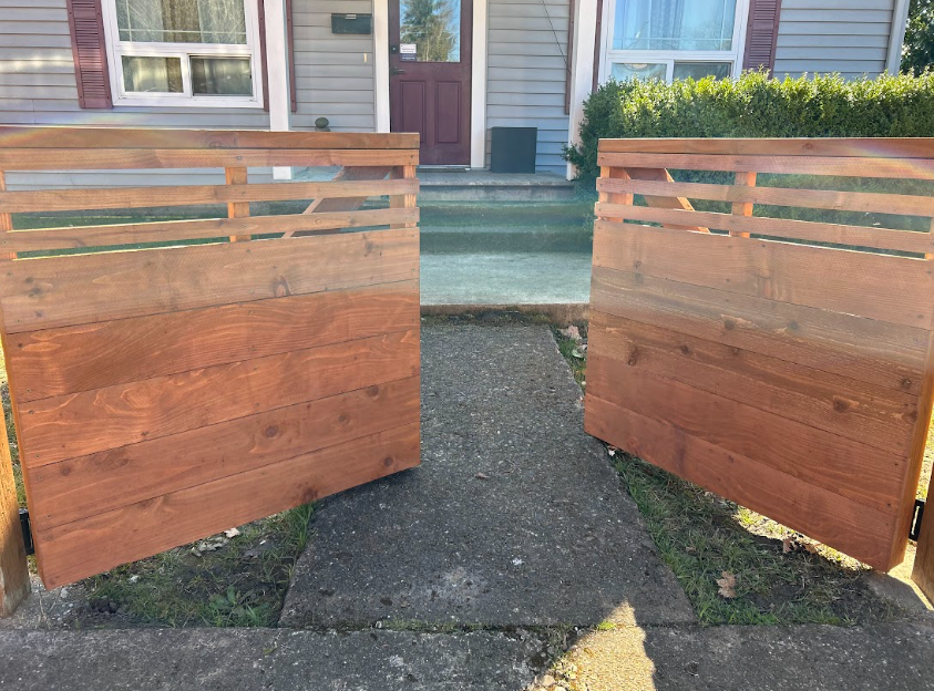 A wooden deck with a wooden railing and trees in the background