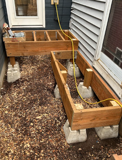 A wooden deck is being built in a backyard.