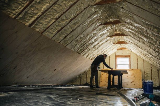 A man is working on a table in an attic.