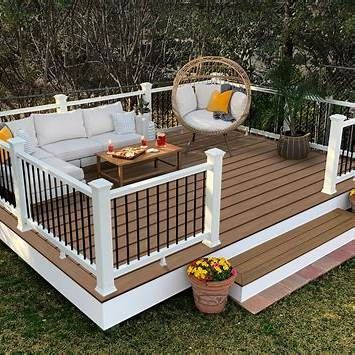 Outdoor deck with seating, including a sofa, a hanging chair, and a small table.