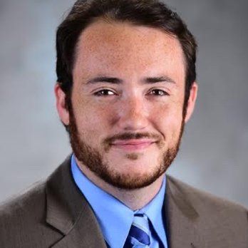 A man with a beard is wearing a suit and tie.