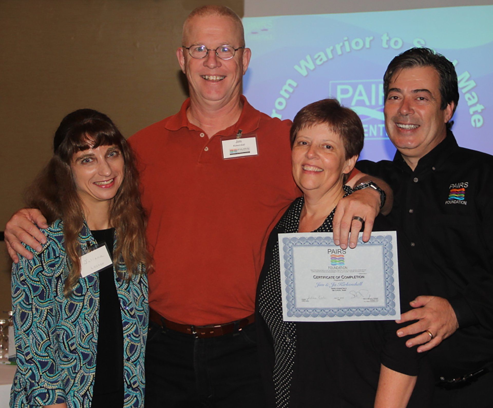 A group of people posing for a picture in front of a sign that says