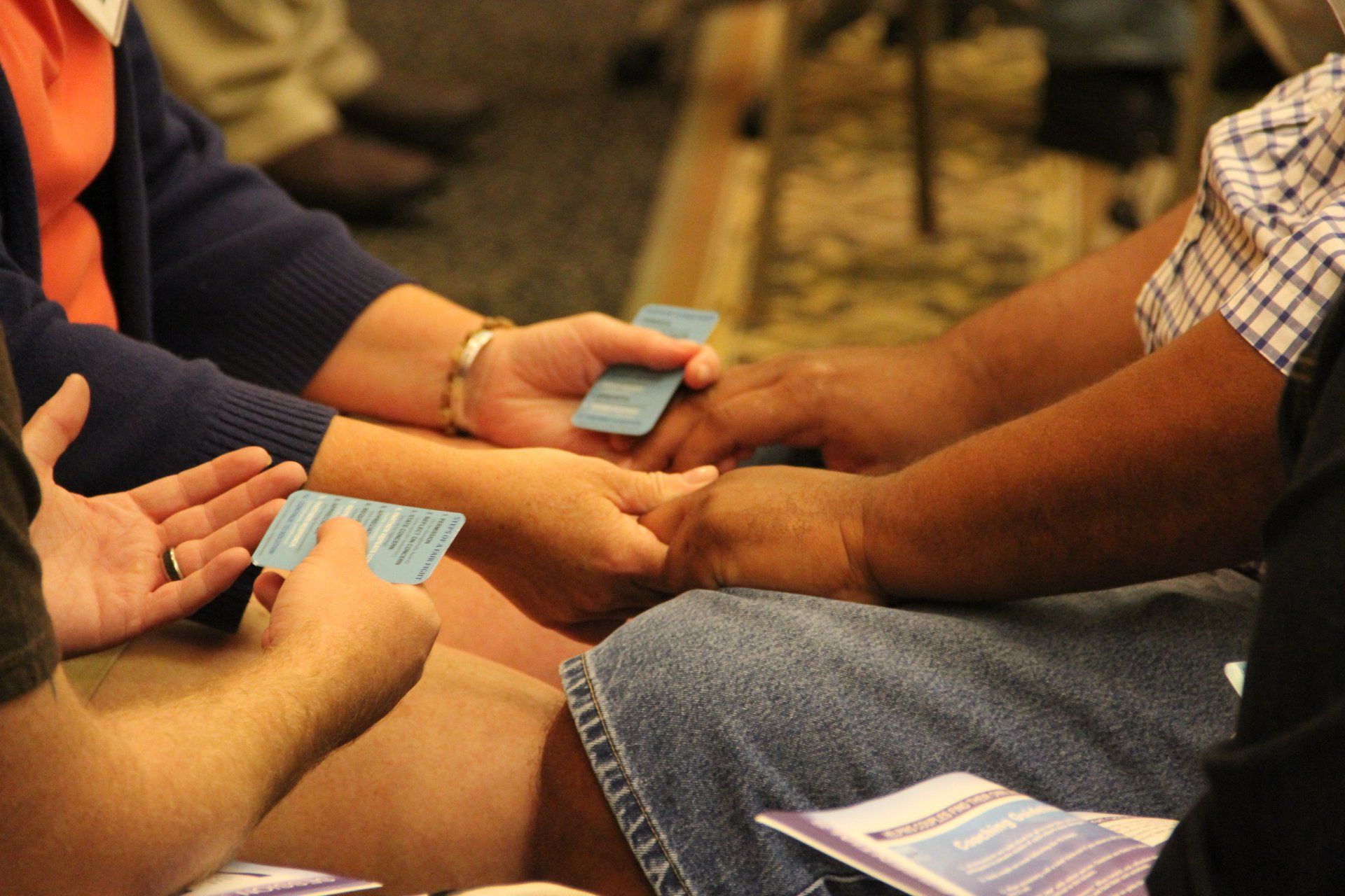 A group of people are holding hands and playing cards