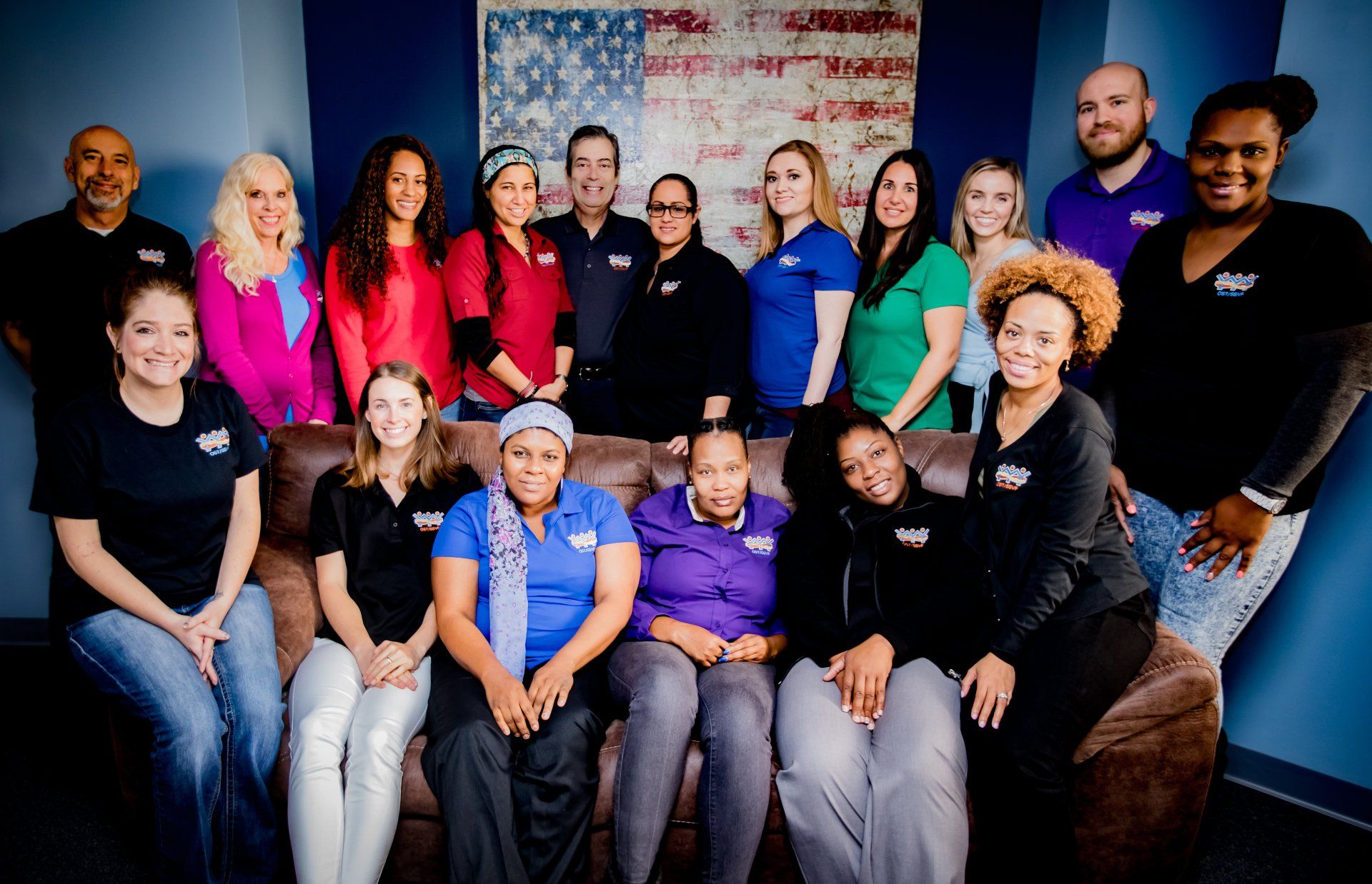 A group of people sitting on a couch posing for a picture
