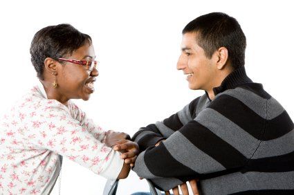 A man and a woman are sitting next to each other and holding hands.