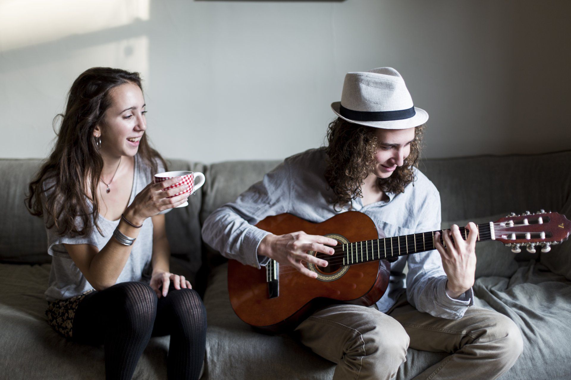 A man is playing a guitar while a woman sings.