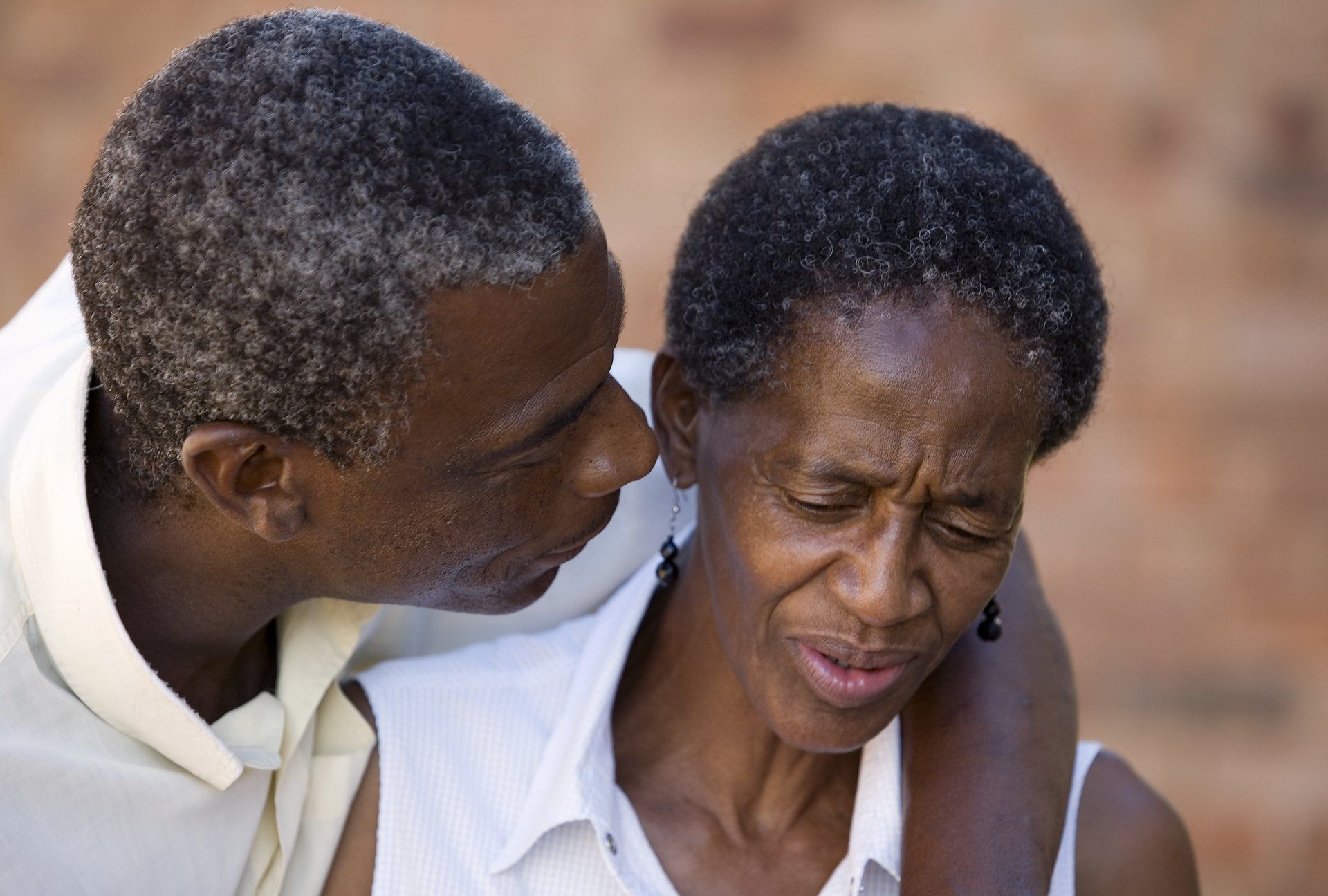 A man is kissing a woman on the cheek.