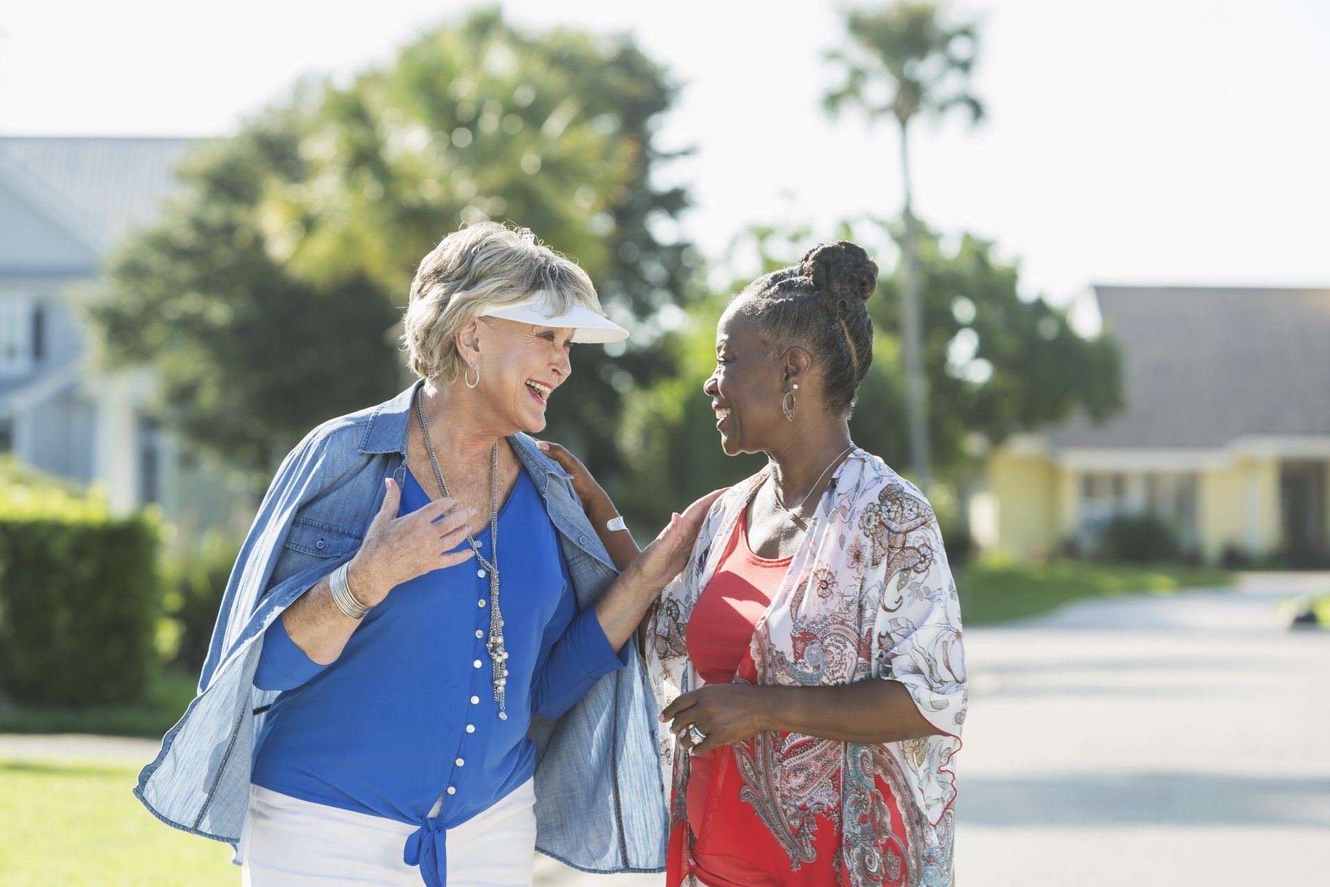 Two women are walking down the street and talking to each other.