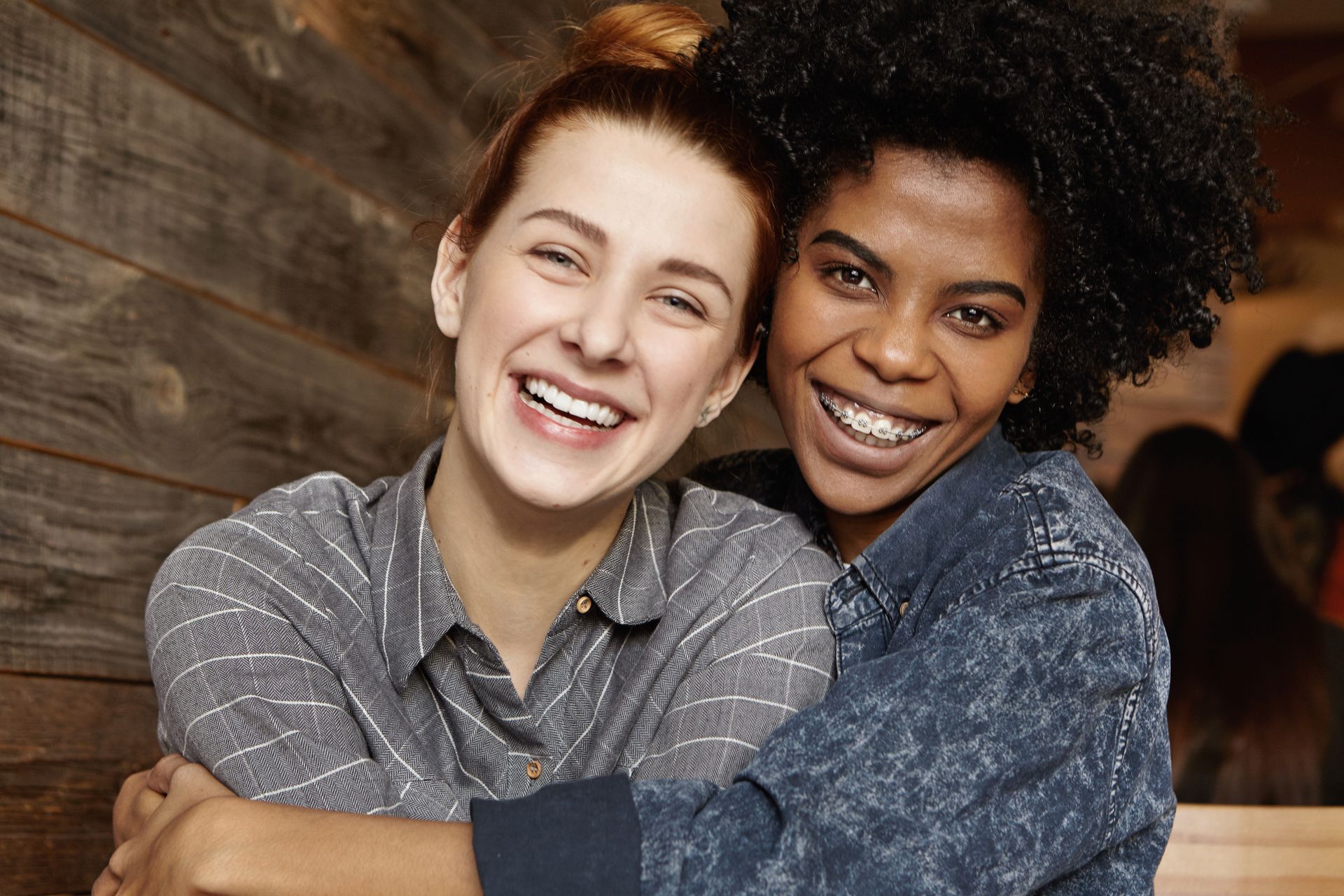 Two women are hugging each other and smiling for the camera.