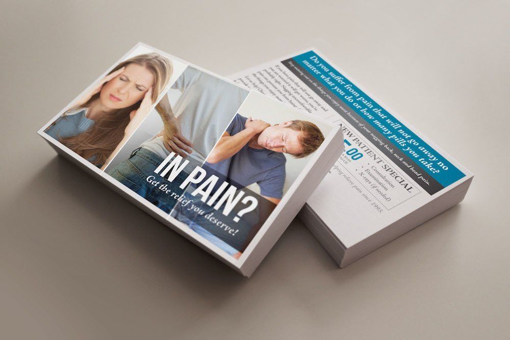 Two business cards are stacked on top of each other on a table.