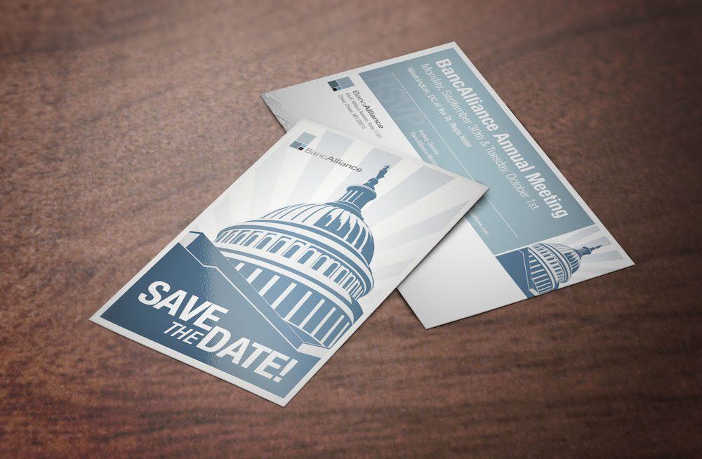 Two save the date cards are sitting on a wooden table