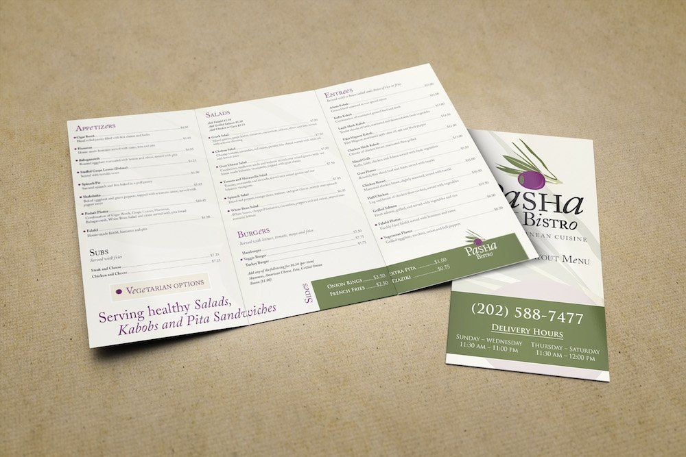 A menu and a business card are sitting on a table.
