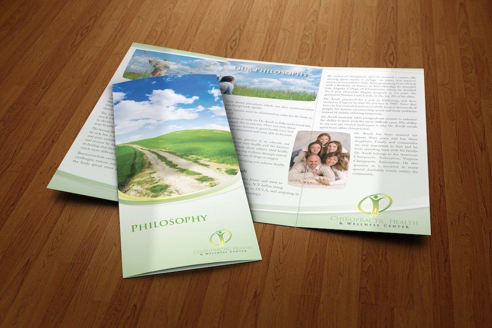 Two brochures are sitting on a wooden table.