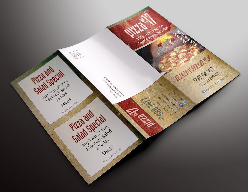 A pizza and salad special brochure is sitting on a table.