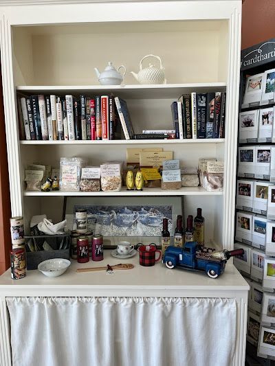 A bookshelf filled with books , greeting cards , and other items.