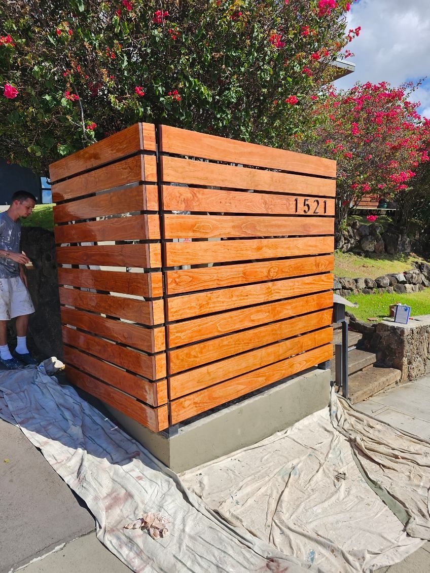 A man is standing next to a wooden fence.