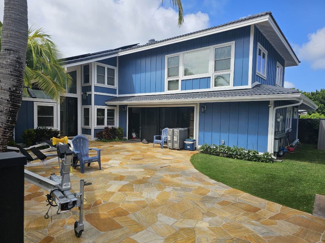 A large blue house with a trailer parked in front of it.
