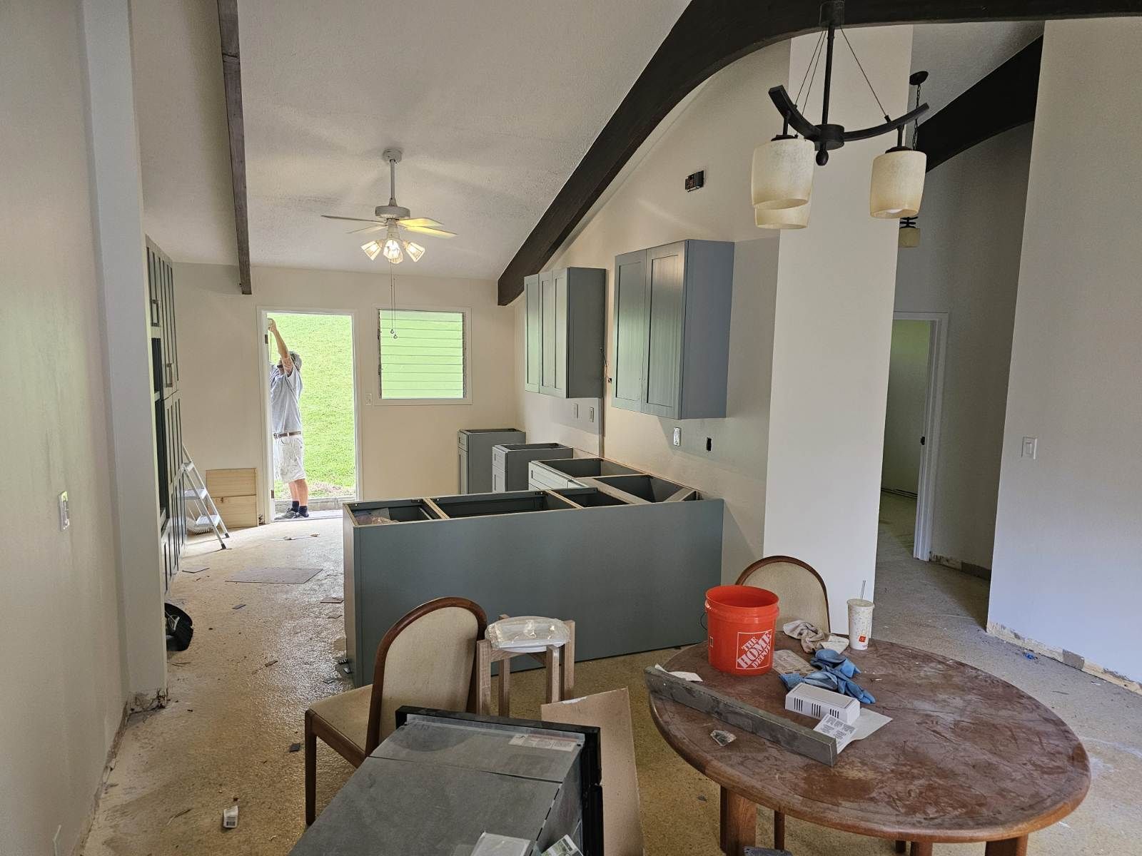 A kitchen under construction with a table and chairs
