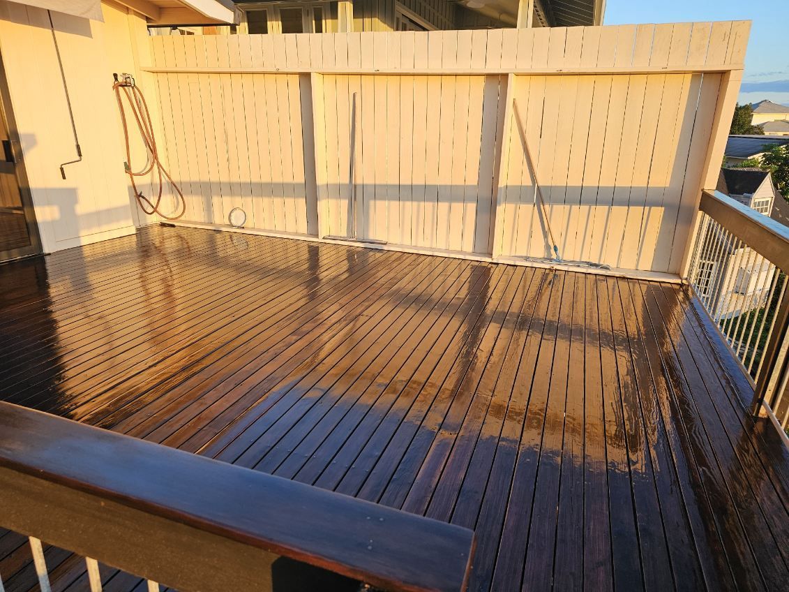 A wooden deck with a white fence in the background