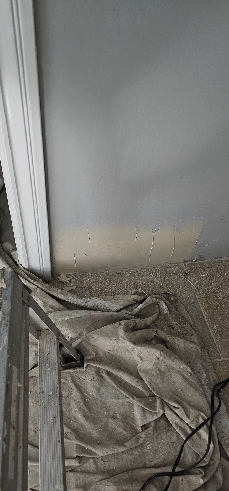 A ladder is sitting on the floor next to a wall.