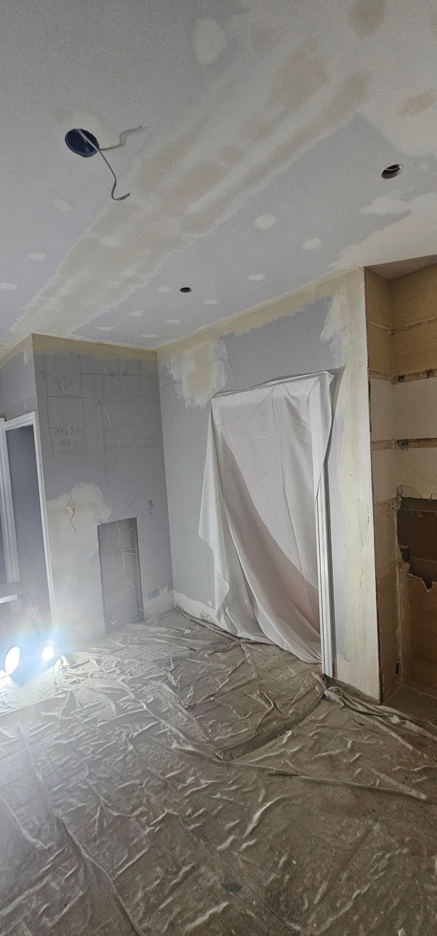 A living room with a ceiling that is being painted.
