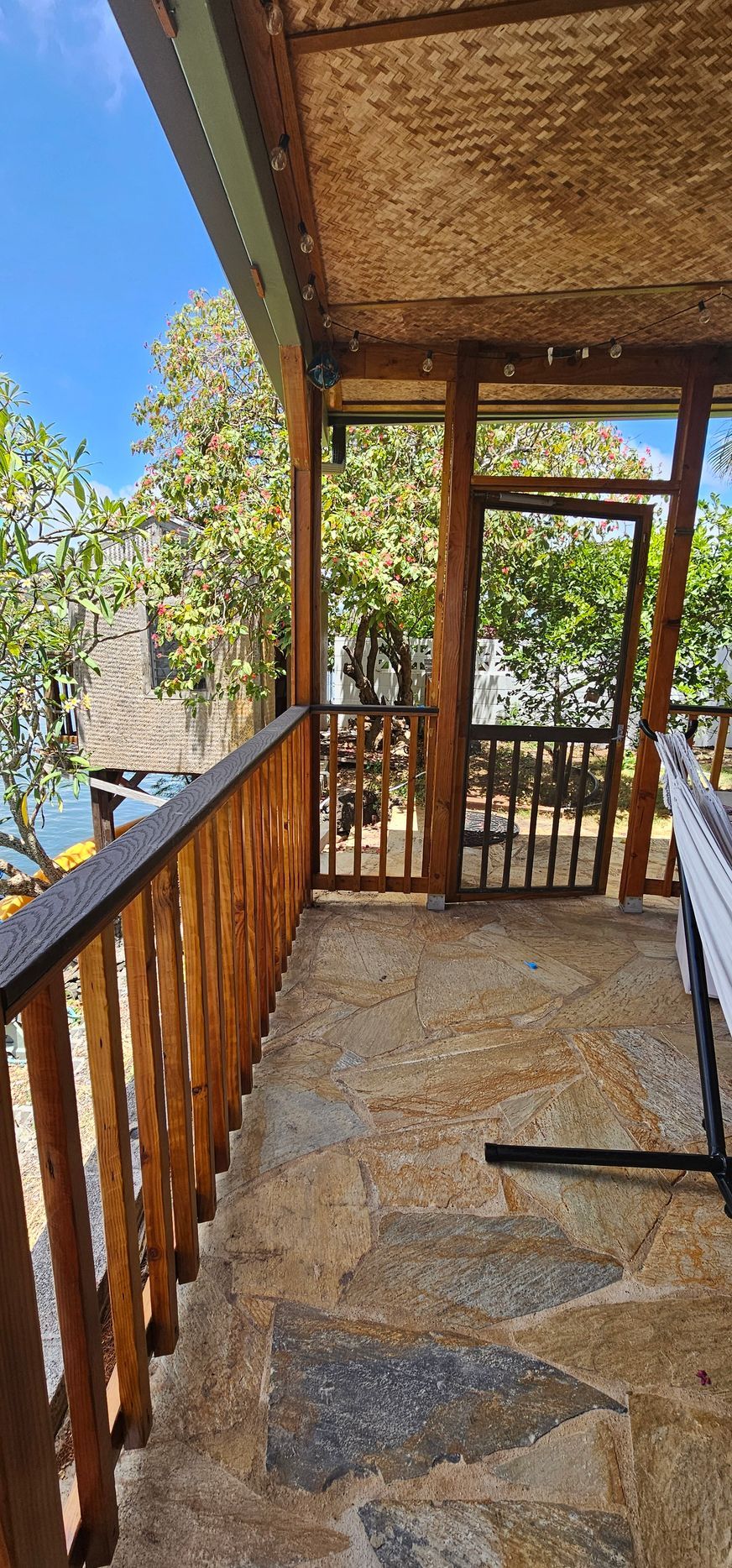 A screened in porch with a wooden railing and a table.