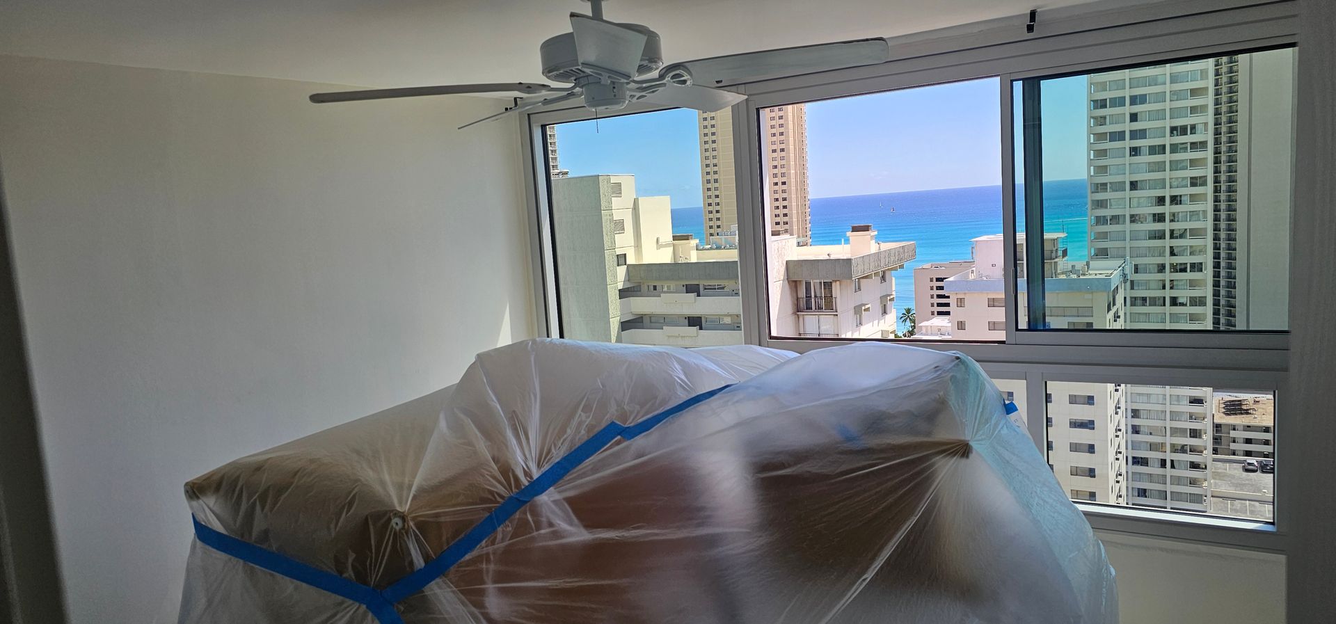 A room with a ceiling fan and a view of the ocean