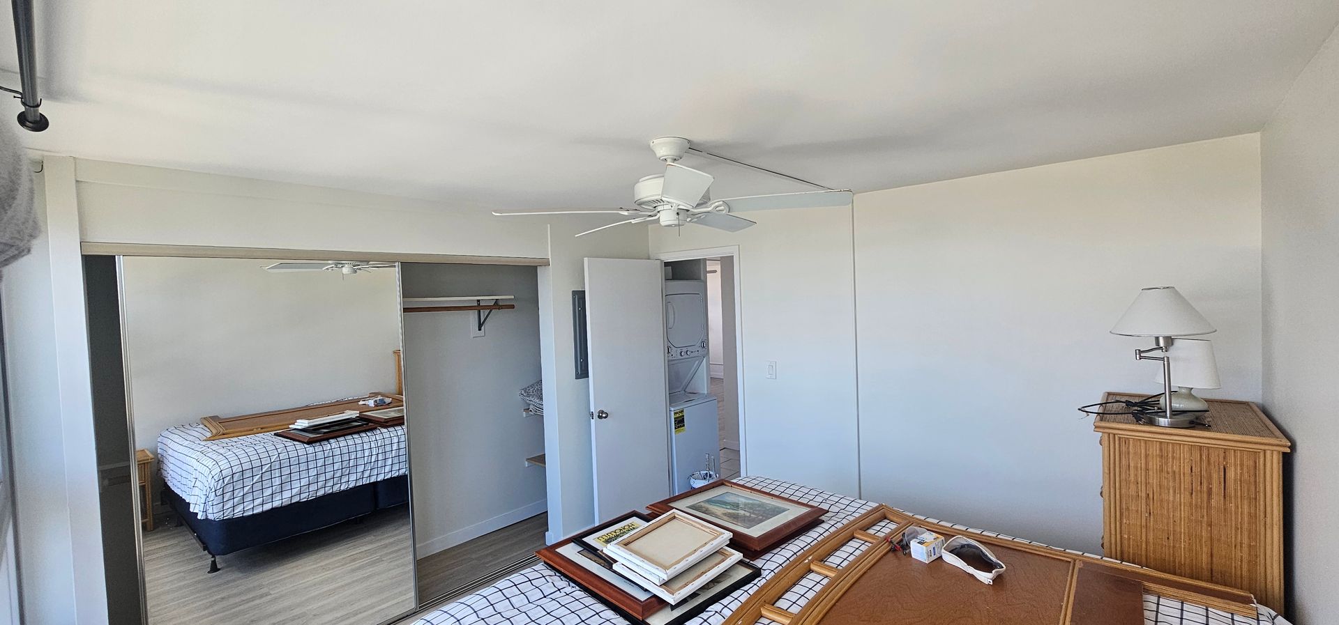A bedroom with a bed and a ceiling fan