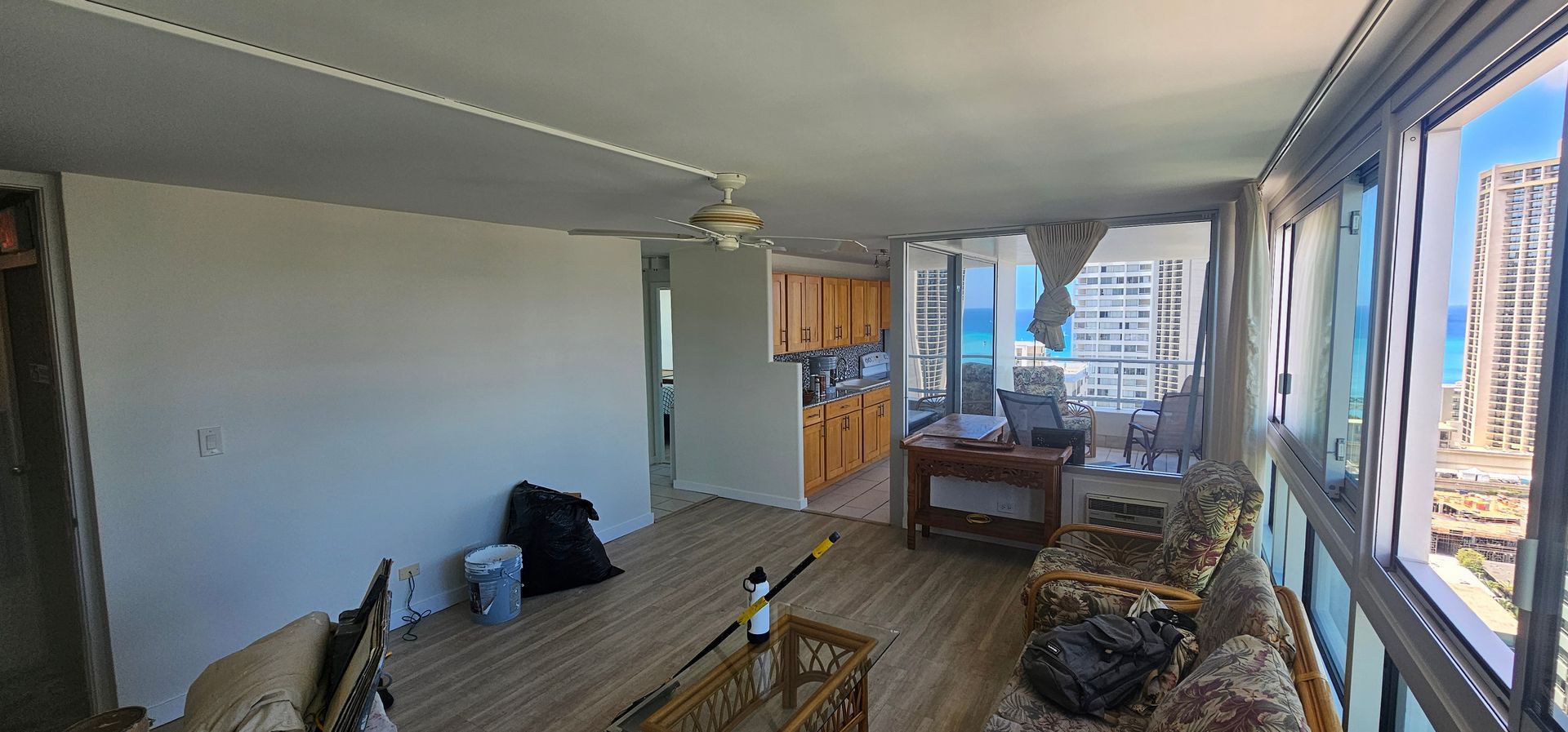 A living room with a couch , table , chairs and a ceiling fan.