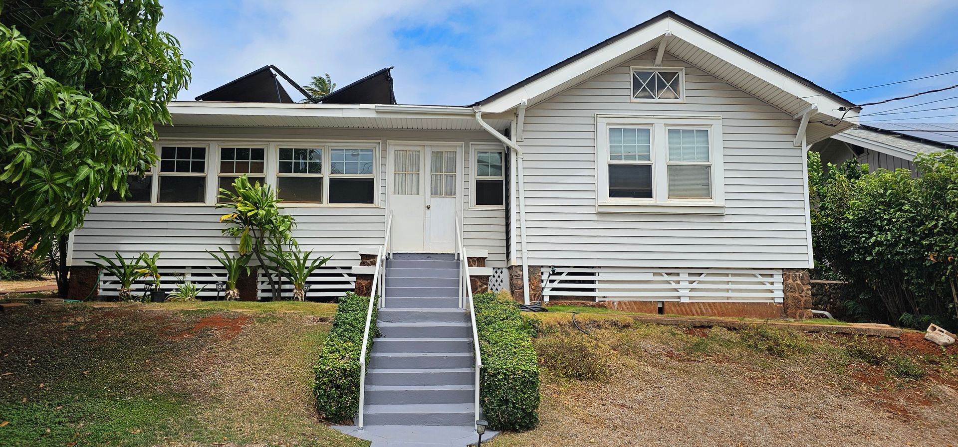 A white house with stairs leading up to the front door