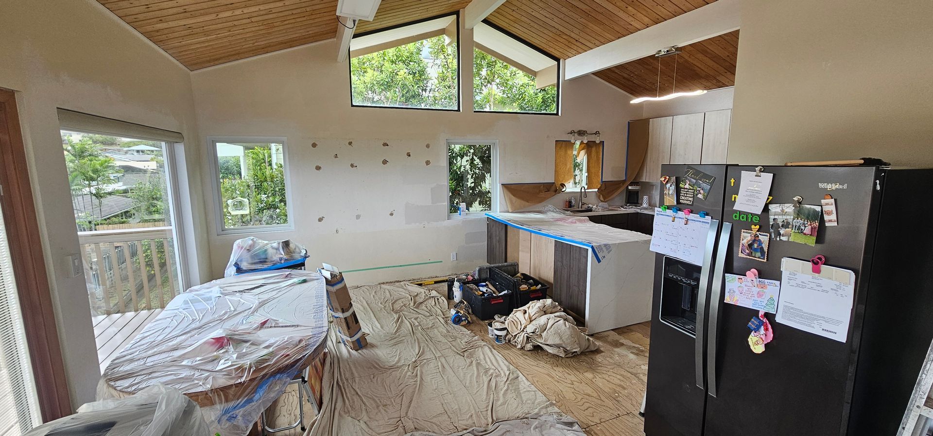 A kitchen with a refrigerator and a table in it.