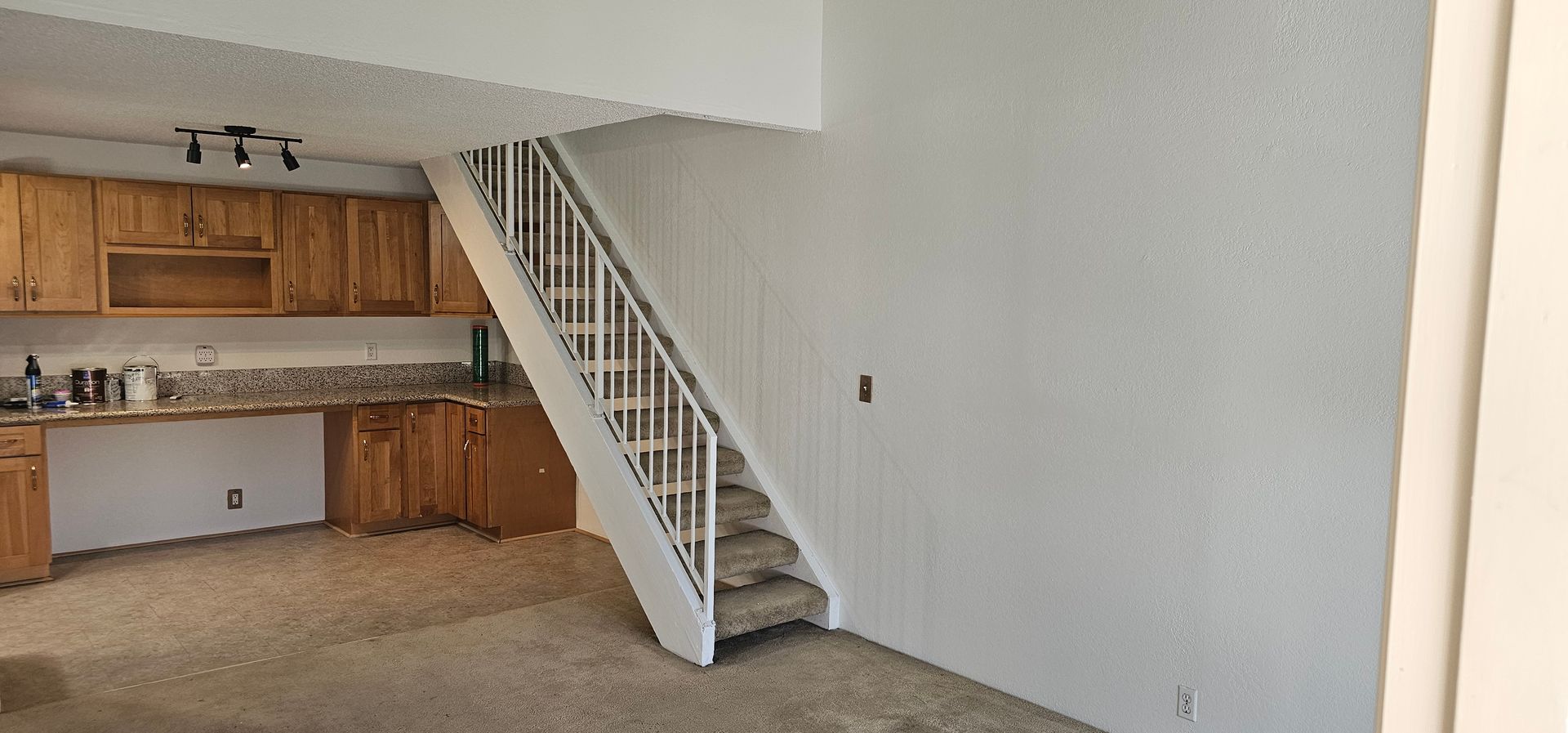 A kitchen with a staircase leading up to the second floor.