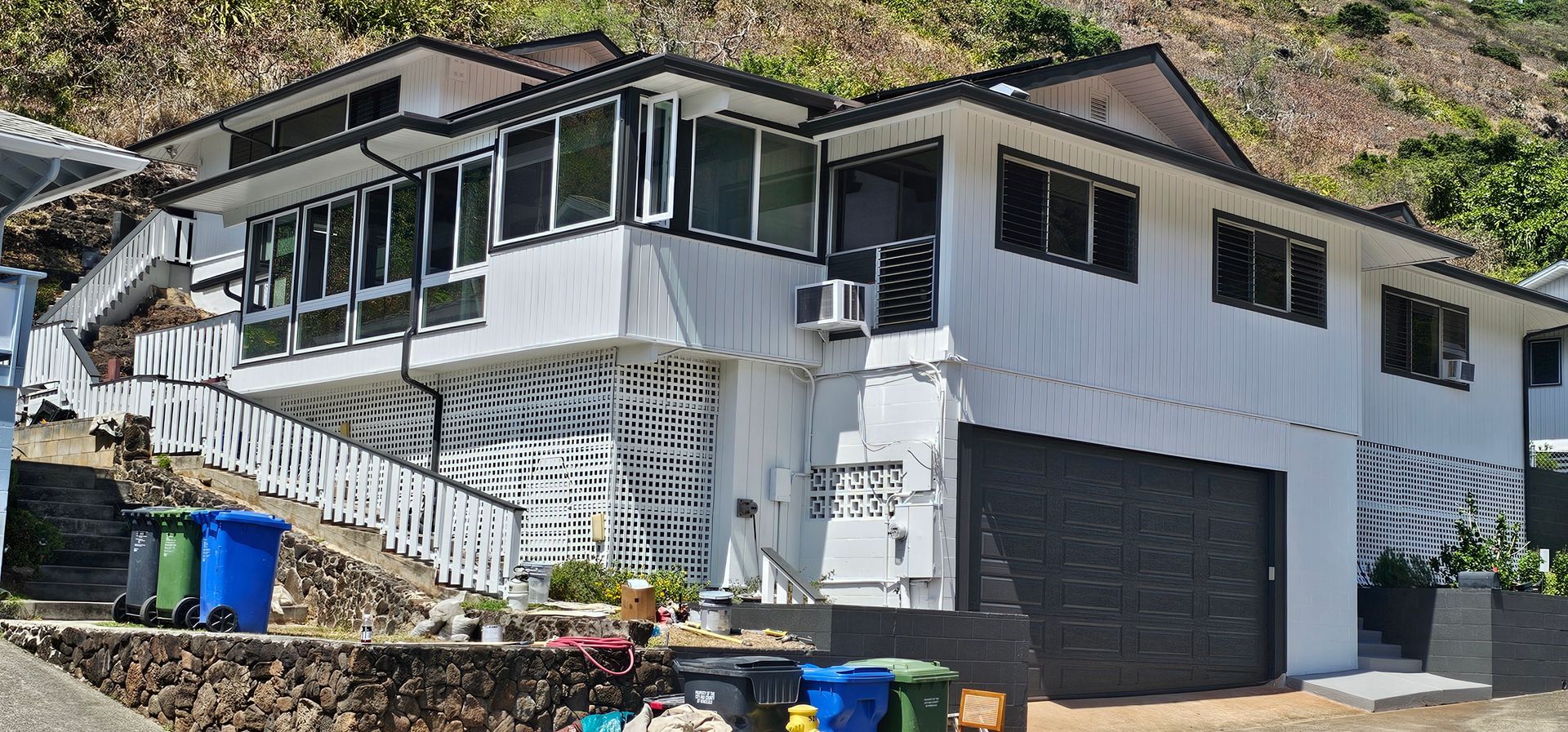 A large white house is sitting on top of a hill.