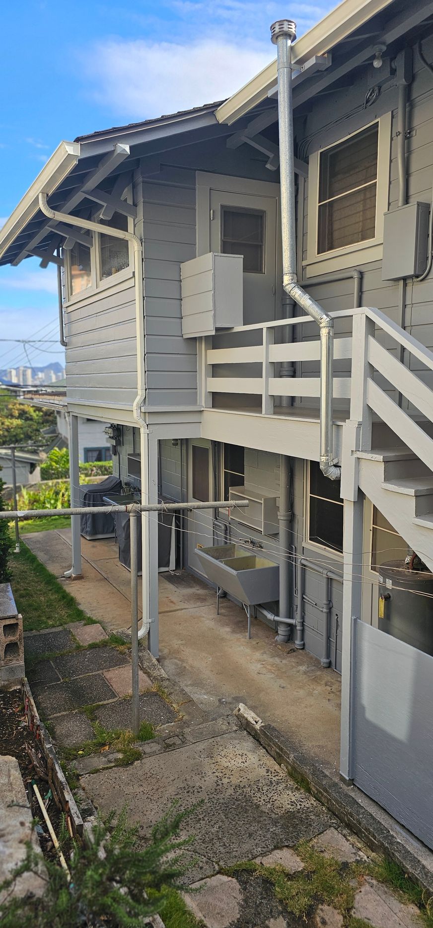 A house with stairs and a balcony on the side of it.