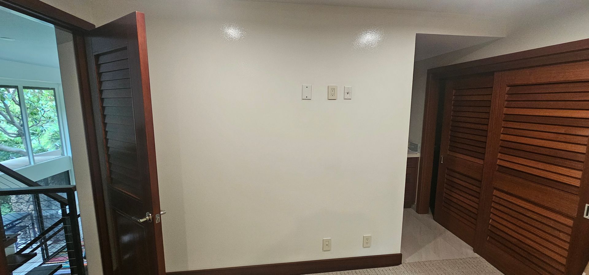 An empty room with a wooden door and a white wall.