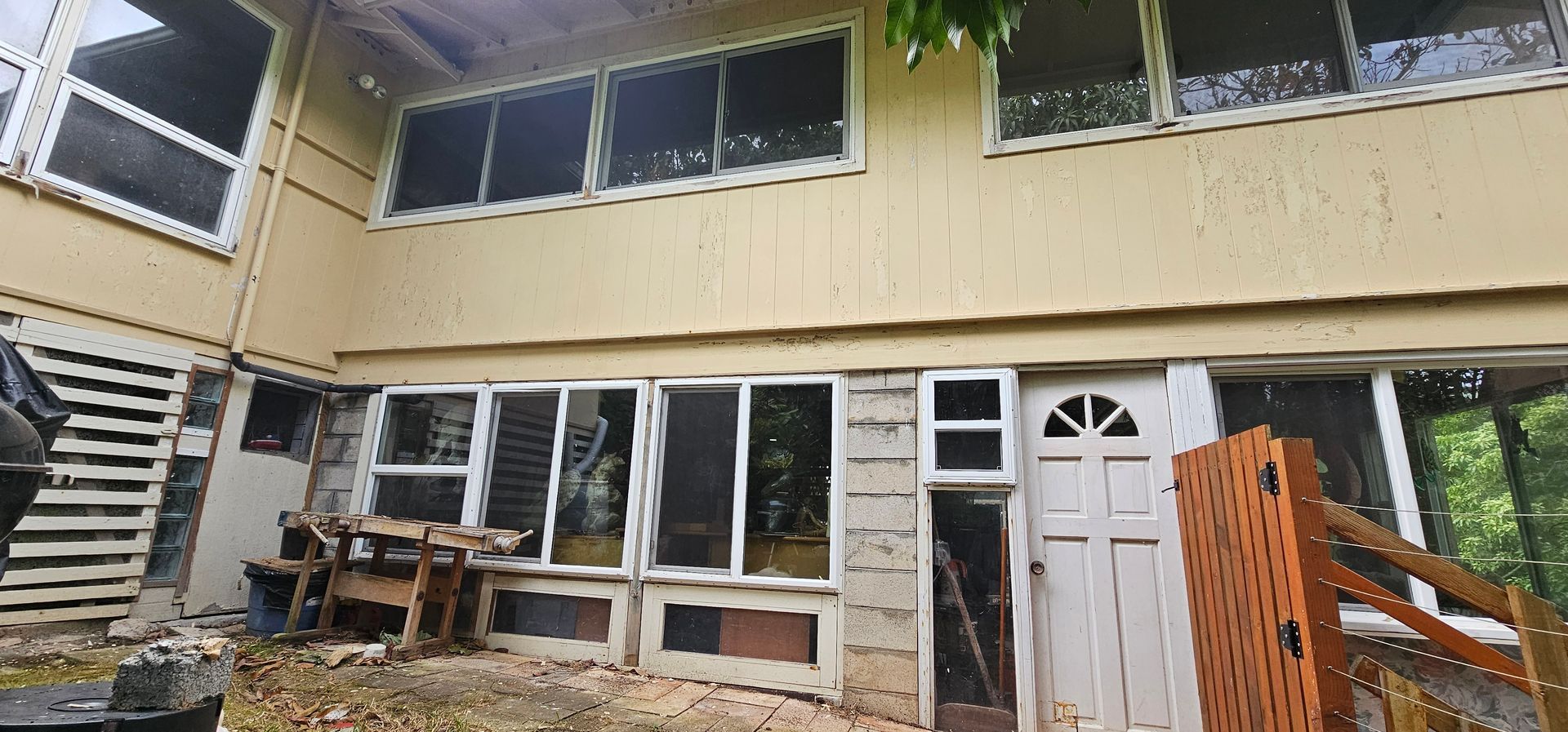 The back of a house with a lot of windows and a door.