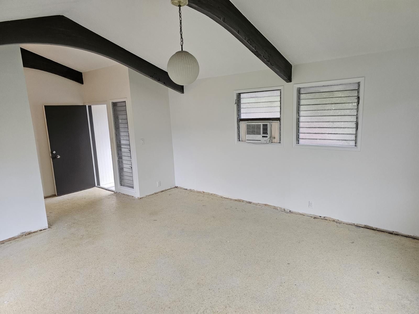 An empty room with white walls and a ceiling fan